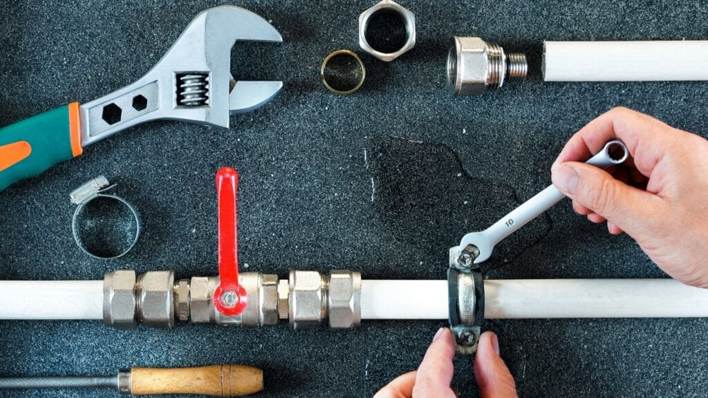Plumber repairing a pipe valve with an adjustable wrench in Jacksonville