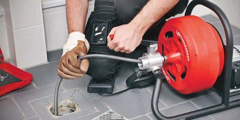 Plumber using a drain-cleaning machine in Jacksonville