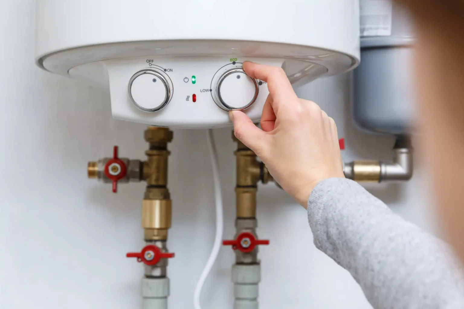 Homeowner adjusting the temperature controls on a water heater in Jacksonville